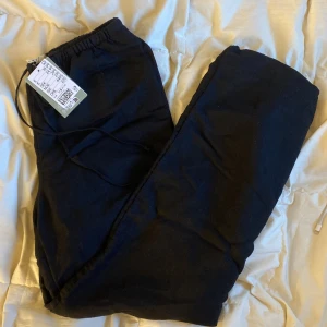 Svarta byxor med dragsko - Ett par helt nya svarta linnebyxor ifrån H&M. De har en knytning längst midjan och fickor på vardera sida. Fickor på baksidan. 