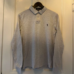 Ralph Lauren piké S/M - Ralph lauren tröja i färgen grå. Storlek M men passar S/M. Nyskick, inga skavanker. Nypris 1299 kr, köp för endast 449kr.