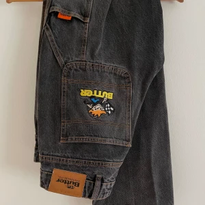 Butter Goods Racing Denim - Asfeta baggy/relaxed jeans av märket Butter Goods. Mindre ”skrap” vid ena bakfickan (se bild) men i övrigt mycket bra skick.  Benöppning: 21 Ytterbenslängd: 100 Innerbenslängd: 73 Midja: 40 1/2 Knä: 26    (Se min annons för måtthänvisning)