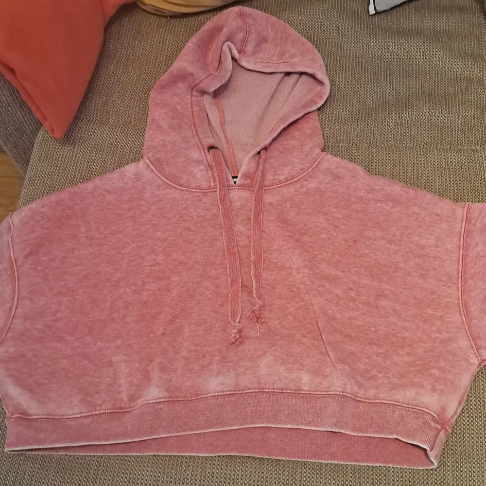 Säljer en supermysig rosa croppad hoodie. Den har en skön luva med dragsko och är perfekt för en avslappnad stil. Materialet känns mjukt och bekvämt, perfekt för chilliga dagar. Passar perfekt till jeans eller leggings!. Hoodies.