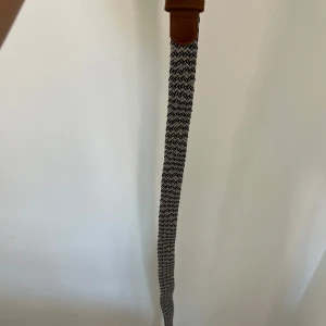 Grisch bälte svart vit grå  - helt nytt skick aldrig använt innan. färg vit grå svart