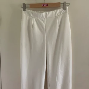 Kostymbyxor vit Nelly - Vita kostymbyxor från Nelly med slits längst ner. Storlek S, men stretchiga så passar mig som ligger mellan S-M. 