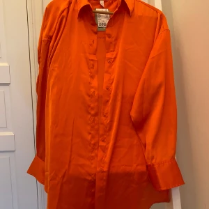 Blus HM - Orange blus, längre modell. 