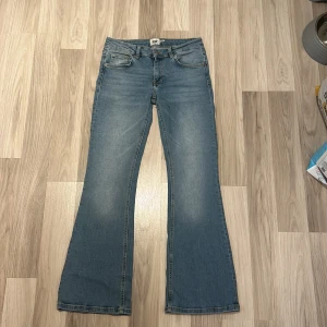 Lager 157 Jeans - Säljer ett par snygga blå bootcut jeans från Lager 157. De har en låg midja och klassisk femficksdesign. Byxorna är i storlek S, SHORT LENGTH. Endast använda 2-3 gånger. Innerbensmått - 73cm. Midjemått rakt över - 36cm.