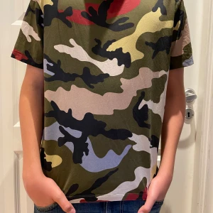 Valentino garavani t-shirt - Säljer denna feta Valentino garavani t-shirten,den är självklart äkta, modellen på bilderna är 170 cm lång, t-shirten är i nyskick förutom tre pyttesmå hål som man ser på sista bilden men dem syns inte vid användning pga mönstret och attdem är så små