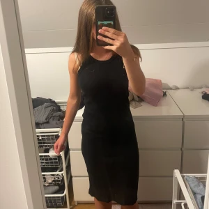 Svart ärmlös klänning - En lång svart klänning som är ärmlös och har en tight passform. storlek XS men jag skulle säga att det passar S också.