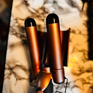 Hårstyler i kopparfärg - Säljer en supercool hårstyler i kopparfärg med tre cylindrar för att skapa snygga vågor i håret. Den har en sladd och en EU-kontakt, perfekt för att fixa håret snabbt och enkelt. Perfekt för att få till den där beach-looken året runt! FRI FRAKT