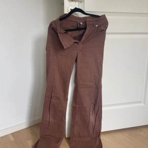 Bruna byxor från H&M Divided - Säljer ett par snygga bruna byxor från H&M Divided. De är i storlek 34 och har en skön passform. Perfekta för både vardag och fest!