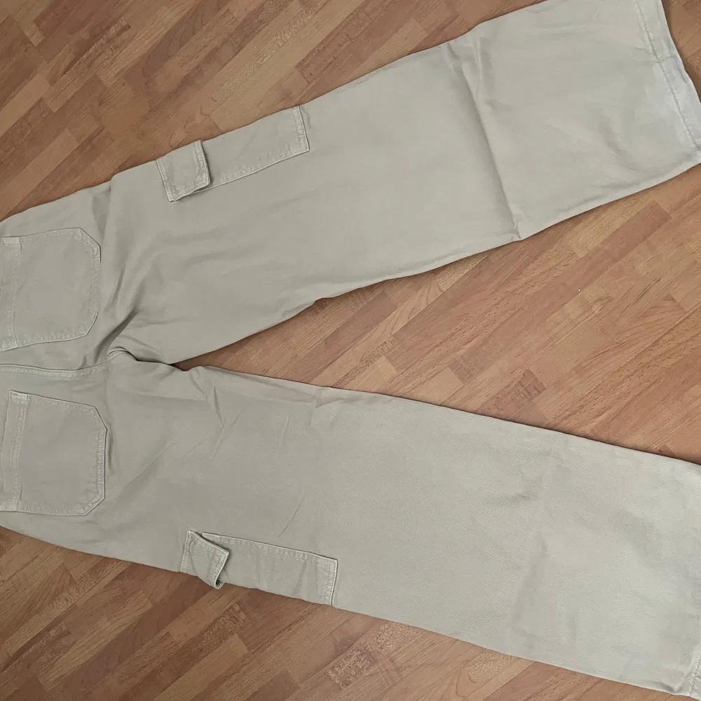 Säljer ett par snygga beige cargopants från Perfect Jeans. De har en loose passform med praktiska fickor på sidorna. Perfekta för en avslappnad stil och passar till de flesta tillfällen. Storlek 34.. Jeans & Byxor.