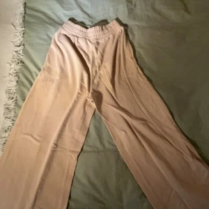 Beige vida byxor - Säljer ett par beige mjukis med hög midja och vida ben. De är superbekväma och perfekta för att chilla hemma men kan användas ute med. 