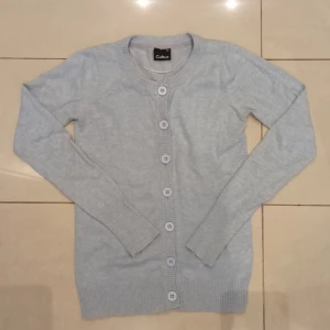 Ljusblå kofta från Cubus - Säljer en superfin ljusblå kofta från Cubus i storlek XS. Den är i nyskick och har långa ärmar med ribbade muddar. Koftan har knappar framtill och är perfekt för alla väder. Den är gjord i mjukt material som känns skönt mot huden. Perfekt att ha över en t-shirt, blus eller linne för en avslappnad, elegant look!💕