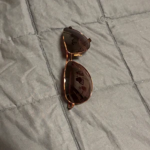 Solglasögon med brun båge - Snygga solglasögon med brun båge och mörka glas. Perfekta för soliga dagar och ger en stilren look. Passar både till stranden och stadspromenader.