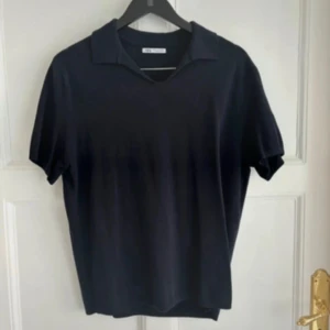 Svart pikétröja från Zara - Snygg svart pikétröja med korta ärmar och klassisk krage. Perfekt för en stilren och avslappnad look.