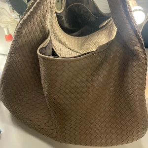 Beige flätad axelväska design by si - Väska från design by si, köpt för ca 600kr. Väldigt rymlig och får olats med bland annat macbook🤭🤗