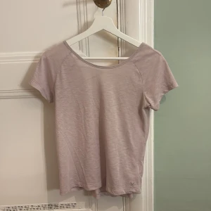 Ljuslila topp från Stadium - Säljer en ljuslila topp från Stadium i polyester. Toppen har korta ärmar och en snygg detalj med korsade band i ryggen. Perfekt för gymmet. Står ingen storlek men skulle säga S!