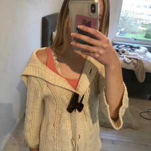 Beige stickad kofta med knappar - Mysig beige stickad kofta med stora knappar framtill. Koftan passar från Xs-M och har trekvartsärmar. perfekt nu när det är kallt!💕
