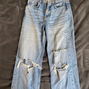 Blå jeans med slitningar från Perfect Jeans - Säljer ett par blå jeans från Gina tricot med slitningar på knäna. Långa och passar dig som är 170. Mid waist och sitter skitbra runt höfterna och midjan 😮‍💨(det är storlek 32 men skulle säga att de är större i storleken)