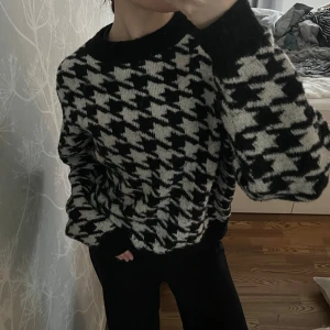 Svartvit stickad tröja - Säljer en snygg svartvit stickad tröja med klassiskt hundtandsmönster. Tröjan har långa ärmar och en bekväm passform!☺️