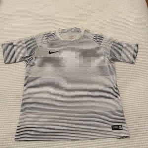 Nike T-shirt - Säljer en riktigt fin tränings T-shirt från Nike utan defekter och dessutom för ett bra pris. Storlek 13-15 år men sitter som XS. Vid minsta fundering är det bara att höra av sig!