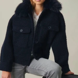 Mörkblå kappa med avtagbar päls  - Snygg blå jacka med pälsdetaljer på kragen. Jackan har knappar framtill och två fickor. Kappan är från Gina tricket Young i storlek 158-164, den är använda 1- 2 gånger och pälsen sitter endast fast i 2 knappar 1 i varje sida men man kan såklart sy på fler fästen i de andra knapparna om man vill.