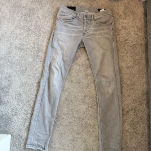 Ljusgrå skinny jeans från Dondup - Snygga grå skinny jeans från Dondup, tillverkade i Italien. De har en klassisk femficksdesign och en smal passform som ger en stilren look. Perfekta för en trendig vardagsstil. Inköpta 2024 kvitto finns. 