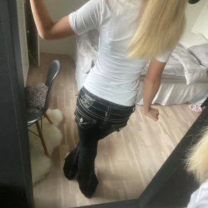 Svarta jeans från True Religion - Snygga svarta jeans från True Religion med vita och röda sömmar och låg midja. Modellen heter Joey och säljs inte längre storlek 24 och passar mig som har midje mått 34/37 och perfekta i längden då jag är 165 använt fåtal gånger