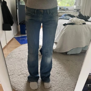 Blå bootcut jeans - Snygga blå bootcut jeans med en klassisk femficksdesign. De har en knapp och dragkedja framtill och är perfekta för en avslappnad stil. Jeansen har en lätt slitning för en trendig look. Midjemått 37 Innerbenslängd 78 💗🤩