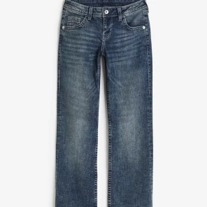 Jeans med knapp på bakfickan - Snygga blå jeans med raka ben/bootcut. De har en knapp och dragkedja framtill samt en unik fickdetalj med knapp på baksidan. Perfekta för en avslappnad stil.