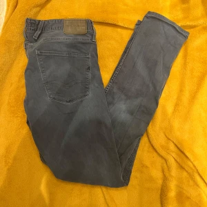 Replay anbass blå 33/33 - Snygga grå jeans från Replay i modellen Anbass. De har en klassisk femficksdesign och en knappgylf. Perfekta för en avslappnad stil.