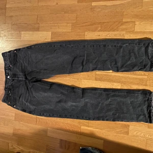 Svarta jeans från Levi's - Snygga svarta Levi's jeans 501. De har en rak passform och är tillverkade i slitstarkt denim. Perfekta för en stilren look.
