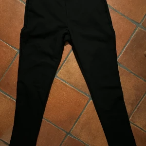 Svarta byxor från Samsøe Samsøe - Snygga svarta byxor från Samsøe Samsøe i en stilren design. Perfekta för en minimalistisk look. Byxorna har en klassisk passform och är tillverkade i ett bekvämt material.