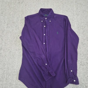 Lila skjorta från Polo Ralph Lauren - Snygg lila skjorta från Polo Ralph Lauren i slim fit. Skjortan är använd ett par gånger.