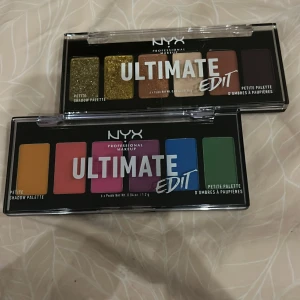 NYX Ultimate Edit Petite Shadow Palette - Två NYX Ultimate Edit Petite Shadow Palettes med olika färgkombinationer. Den ena paletten har jordnära toner inklusive guldglitter, medan den andra har livfulla färger som gul, rosa, lila, blå och grön. Säljer då de aldrig använts eller öppnades 