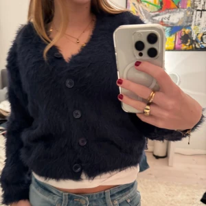 Mörkblå fluffig kofta - Säljer en mysig mörkblå kofta med knappar framtill. Den är väldigt gosig och varm, perfekt nu när det är så kyligt🥰🥰 Så snygg men har alldeles för många stickade därav säljs den❤️❤️❤️