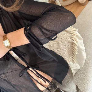 Blus med knytning - Söt ”genomskinlig” blus med knytningar framtill och på ärmarna🖤 Använd enstaka gång 