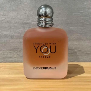 Stronger With You Freeze från Emporio Armani - Säljer en elegant parfymflaska av Stronger With You Freeze från Emporio Armani. Flaskan har en stilren design med en frostad glasfinish och en silverfärgad kork. Perfekt för den som vill ha en fräsch och modern doft.
