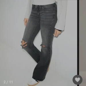 Svarta bootcut jeans med slitningar - Snygga svarta bootcut jeans med slitningar på knäna. De är ny köpta helt oanvända fån nelly