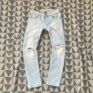 Ljusblå jeans med slitningar - Snygga ljusblå dondup jeans med slitningar på knäna. De är lagade i skrevet och har litet jack över vänstra bakfickan. Skriv om du har några frågor! Priset är inte spikat.