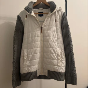 Cardigan med stickade armar - Säljer en snygg vit quiltad jacka med grå stickade ärmar och huva. Storlek L. Jacka är i riktigt fint skick och använd fåtal gånger. Perfekt nu till våren. Hör av dig vid ytterligare frågor!