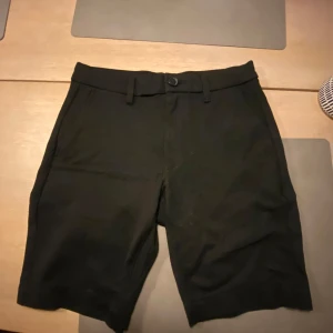 Svarta shorts med knapp och dragkedja - Snygga svarta shorts, perfekt på golfbanan eller en sommarkväll. Storlek XS. Mycket bra skick. Kan fraktas eller hämtas i Skövde mvh Lukas.