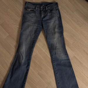 Blå jeans från Diesel Industry bootcut  - Snygga blå jeans från Diesel Industry med en klassisk femficksdesign och knappgylf. Jeansen har en lätt tvättad look och är perfekta för en avslappnad stil. De har en normal passform och är tillverkade i ett slitstarkt denimtyg. 