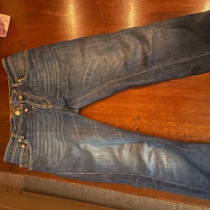 Blå jeans från Jacob Cohën - Snygga blå jeans från Jacob Cohën med klassisk femficksdesign och knappgylf. Jeansen har en stilren tvätt och kontrasterande sömmar som ger en cool look. Perfekta för en avslappnad stil. Modellen ör 180 