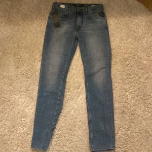 Blå jeans från Replay - Snygga blå jeans från Replay med en klassisk femficksdesign. De har en dragkedja och knapp framtill. Perfekta för en stilren look. W26 L30