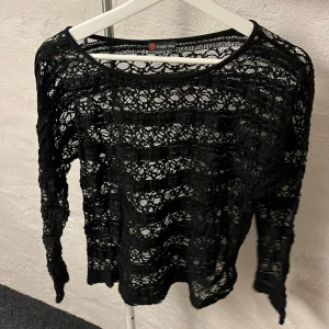 Spetsblus - Snygg svart spetsblus från Street One med långärmad design. Perfekt för att lägga till en elegant touch till din outfit. Blusen har ett vackert spetsmönster som ger en feminin känsla. Den är väldigt liten i storlek så skulle säga att den mer är storlek 38-40 och inte 42