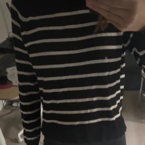 Svart och vit randig tröja - Säljer en stilren svart tröja med vita ränder. Tröjan har långa ärmar och en klassisk passform som passar perfekt till vardags. Perfekt för höst och vinter!