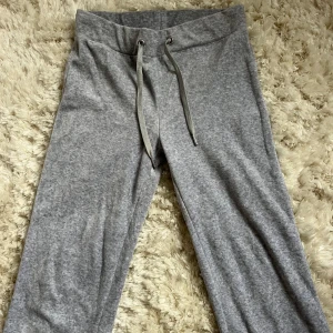 Grå mjukisbyxor från Gina Tricot - Säljer ett par grå mjukisbyxor från Gina Tricot i storlek XS. Byxorna har en bekväm passform med snörning i midjan för justerbarhet. Har sytt upp dessa pga för långa. Perfekt om man är en kort tjej.