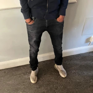 Svarta  jeans från Replay - Snygga svarta jeans från Replay med en klassisk femficksdesign. De har en diskret logga på myntfickan och en snygg tvättad look. Perfekta för en avslappnad stil.