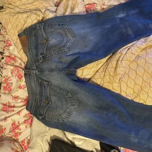 Blå True Religion jeans  - Säljer ett par klassiska blå jeans från True Religion. De har en snygg design med flared passform fickor och märkets ikoniska sömmar. köpta på en thrift store.