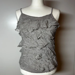 Volangtopp med paljetter/glitter - Super fint  linne med volanger och paljetter. Passar xs-s. Köp sker via köp nu, jag postar inom 24h. Kvar tills markerad såld 