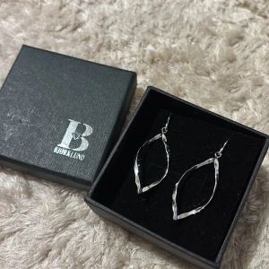 Silvriga örhängen från Bjørklund - Snygga silvriga örhängen från Bjørklund i en elegant vriden design. Perfekta för att ge en stilren touch till din outfit. Passar till alla tillfällen och är helt nya
